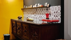A kitchen with a wooden cabinet, a red stove, and patterned tiles on the wall. - Funky Flat (Sofia)