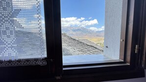 A window with a view of a mountainous landscape. - Denis Guest House (Gjirokastër)