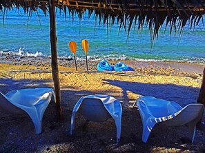 A beach with two kayaks and a thatched roof structure. - Blue Bay Resort (Mele)