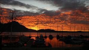 A marina with boats docked at sunset. - Albergo Sole (Cannero Riviera)