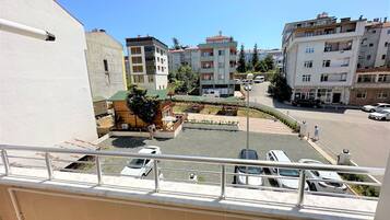 A residential area with multi-story buildings, a small park with a gazebo, and a street with parked cars.