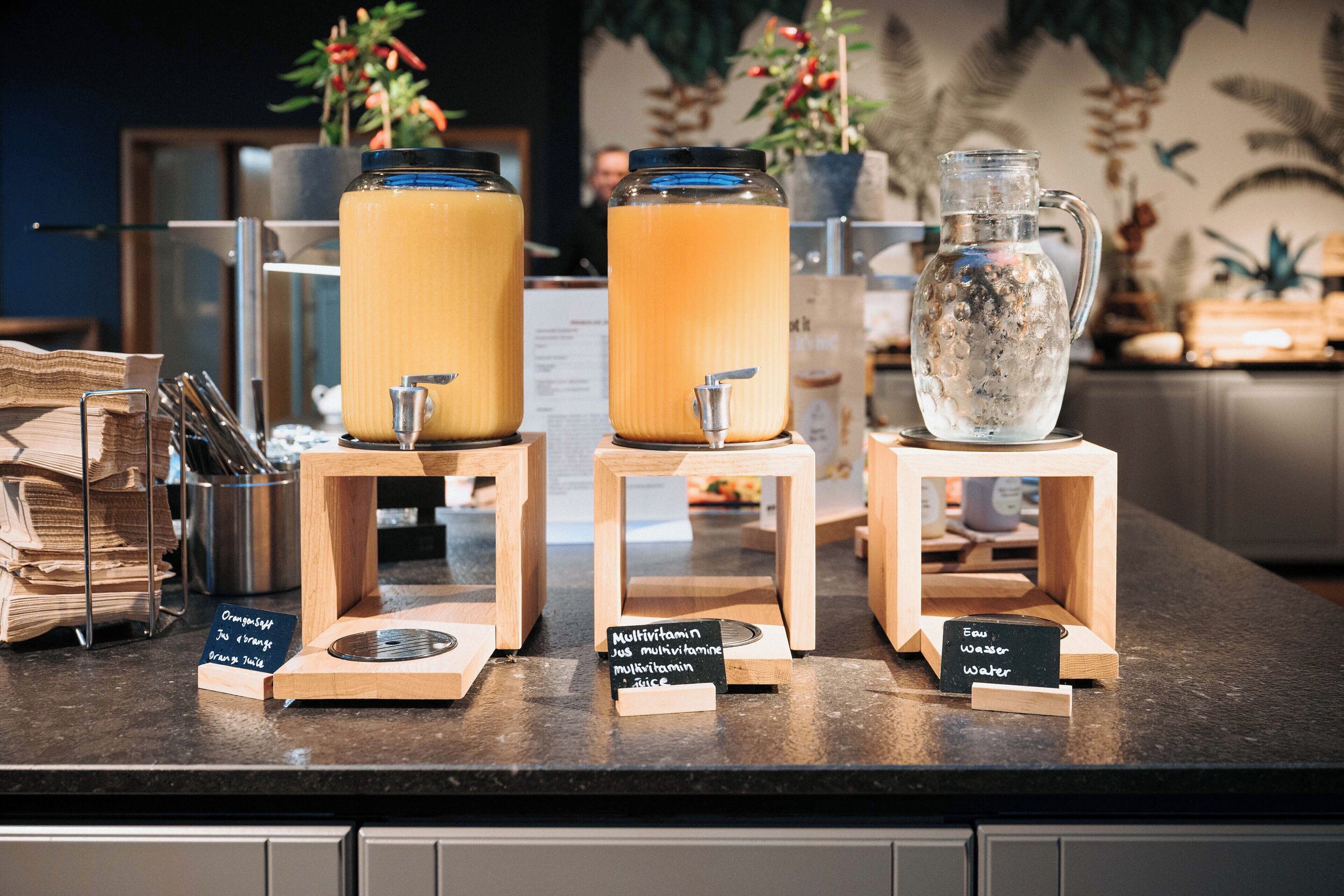 A beverage station with three dispensers, each with a sign indicating the type of drink.