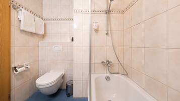 A bathroom with a toilet, a sink, a shower, and a bathtub.