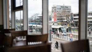 A view from inside a building with large windows overlooking a street with buses and a cyclist. - ates Hotel Straßburg - Kehl (Kehl)