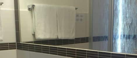 A bathroom with a white sink, a mirror, and a towel rack.