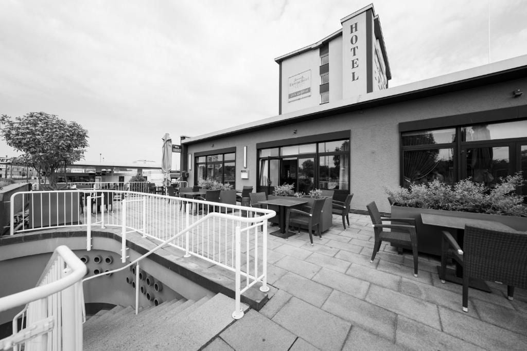 A hotel with outdoor seating, a staircase, and a sign indicating it is a hotel.