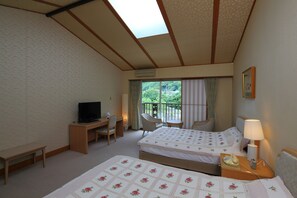 Ein Hotelzimmer mit zwei Betten, einem Schreibtisch mit Fernseher, einem Sessel, einem kleinen Tisch und einem Balkon mit Blick auf Grünflächen.