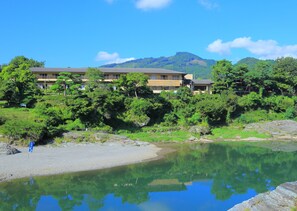 Ein Hotel mit mehreren Etagen, umgeben von üppiger Vegetation und blauem Himmel.