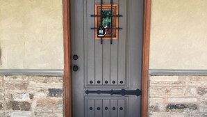 Uma porta com tapete de boas-vindas, uma fechadura e um olho mágico.
