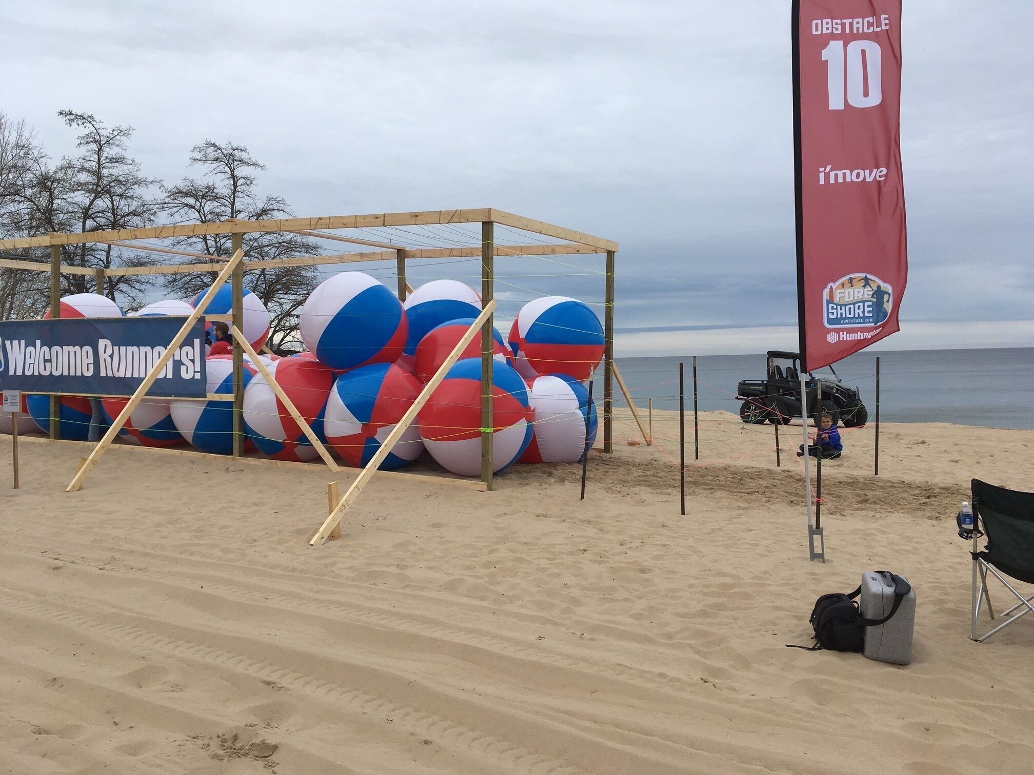 Une animation sur la plage avec de grands ballons gonflables, un panneau d’accueil et un drapeau.