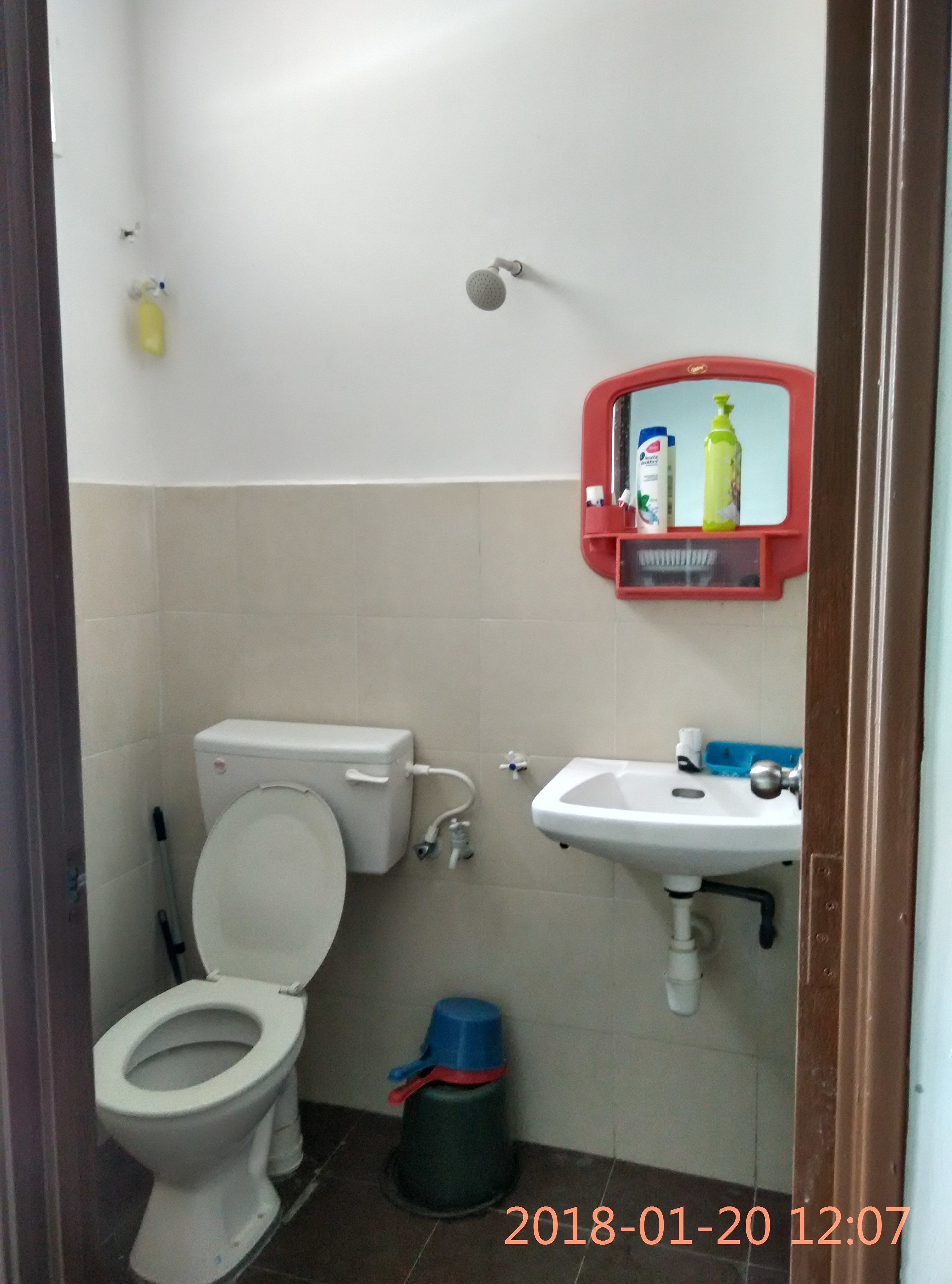 A small bathroom with a toilet, sink, and a red medicine cabinet.