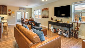 A living room with a sofa, dining table, chairs, a TV, and a ceiling fan. - 30 Mi to Crested Butte: Dog-Friendly Home By River (Gunnison)