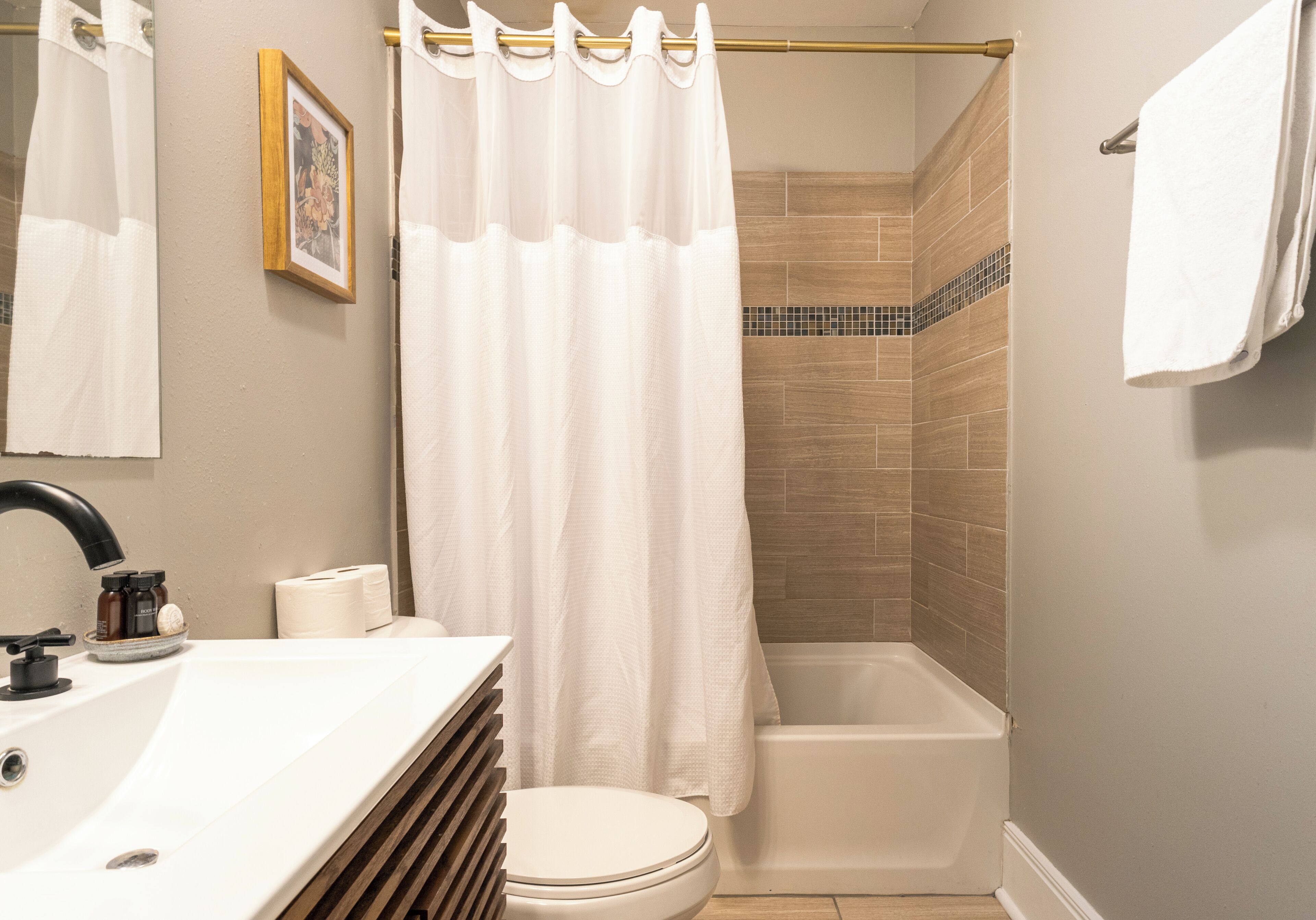 A bathroom with a toilet, sink, and shower curtain.