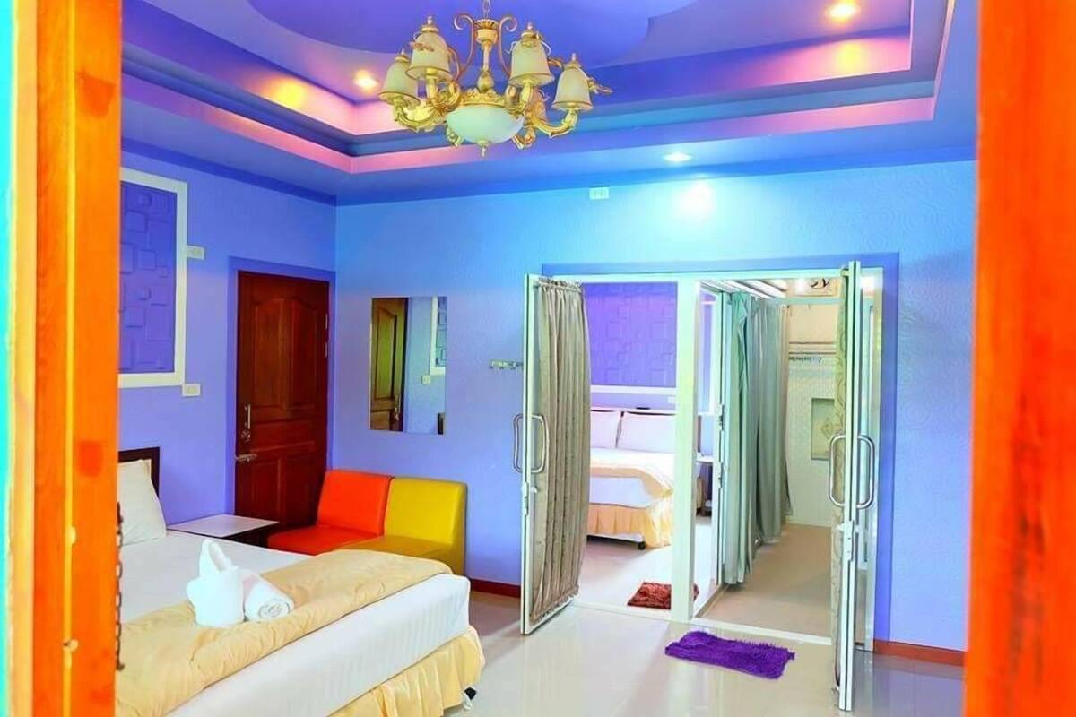 A hotel room with a bed, a chair, a desk, and a bathroom visible through an open door.
