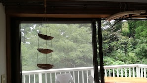 A room with a sliding glass door leading to an outdoor deck. - kuu and fuu (Oshima)