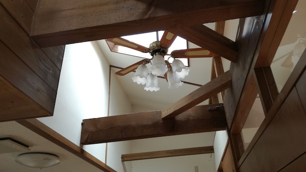 A ceiling with wooden beams and a chandelier. - kuu and fuu (Oshima)