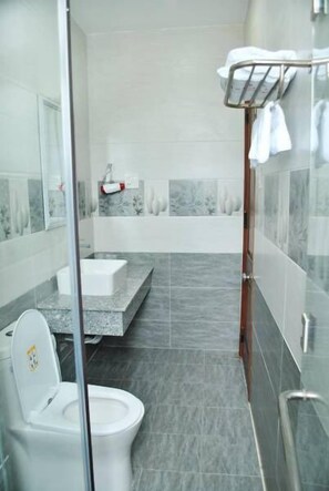 Un baño moderno con cabina de ducha de vidrio, inodoro blanco, lavabo y bañera.