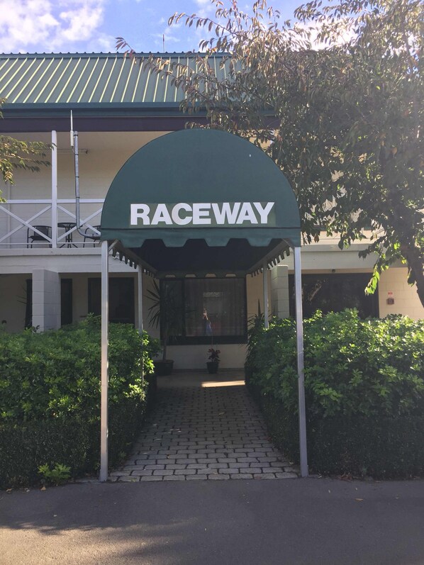 A building entrance with a green canopy labeled "RACEWAY".