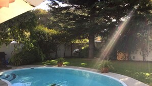 A swimming pool with a curved edge, surrounded by a concrete deck. - Raceway Motel (Christchurch)
