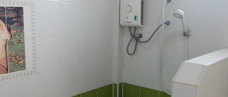 Un baño pequeño con azulejos, ducha, inodoro y ventana.