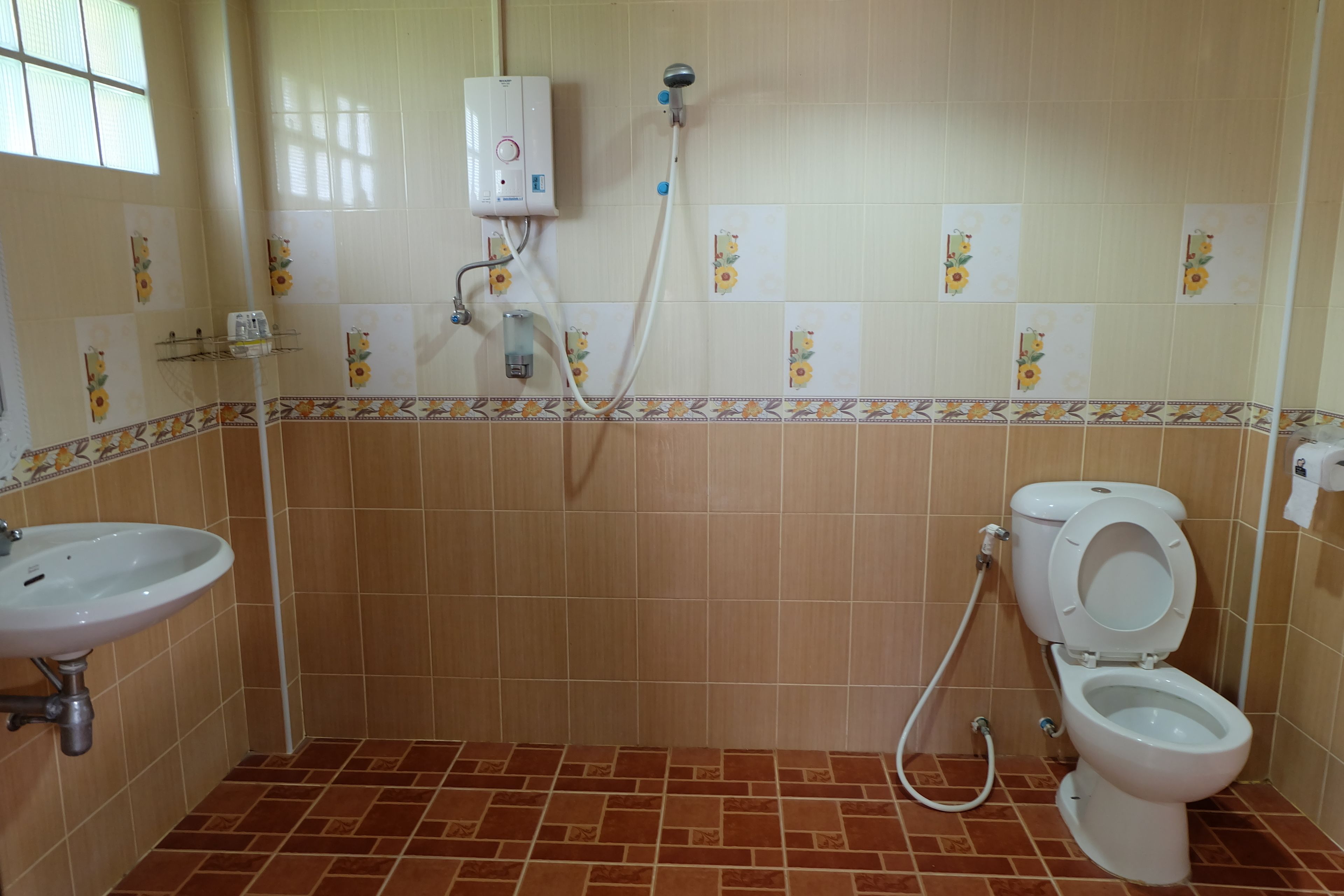 A bathroom with a shower, toilet, and sink.