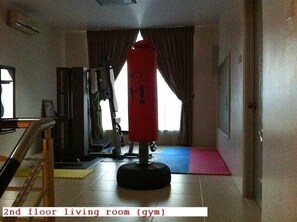 Exercise and relaxation come together in this versatile living space, featuring a punching bag and exercise machine.