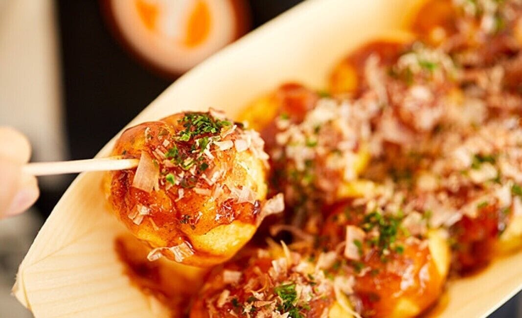 Un plato de comida con un pincho, adornado con ingredientes picados.