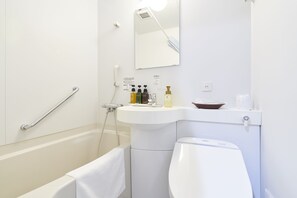 A modern bathroom with a bathtub, a toilet, a sink, and a shower. - Eins Inn Umedahigashi (Osaka)