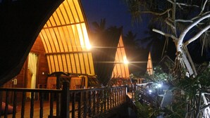 A wooden structure with a curved roof, a wooden deck, and a railing. - Gili Lumbung Bungalow (Gili Air)