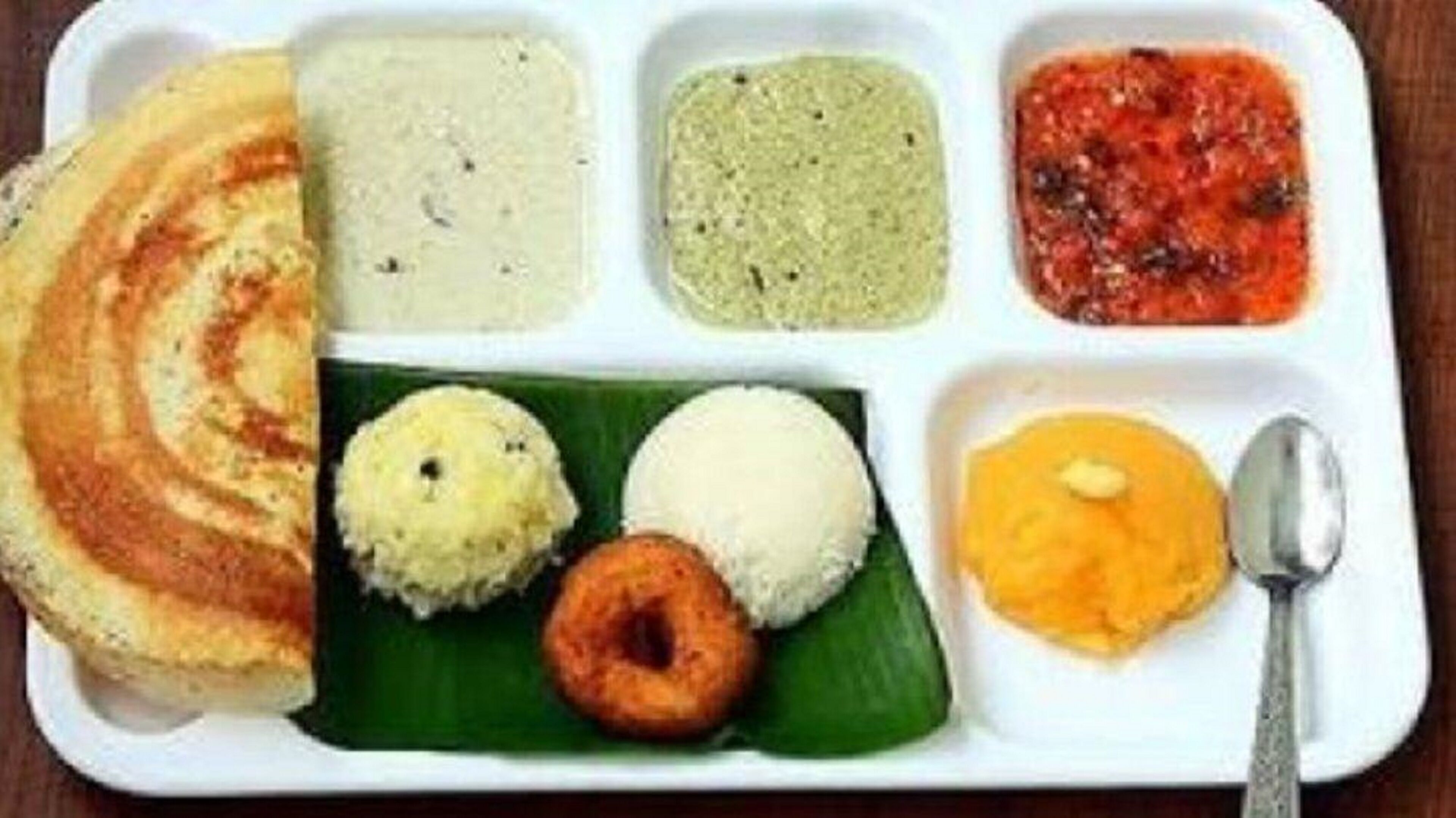 A meal tray with various dishes including rice, a vegetable dish, and a lentil dish.