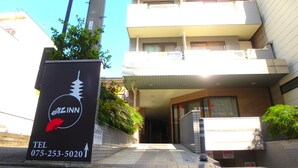 An exterior of an Eliz Inn building with a signboard displaying the name and contact number. - Elitz INN Third (Kyoto)