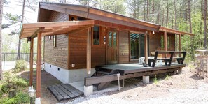 A wooden cabin with a porch, a bench, and a table. - Runesu Karuizawa (Tsumagoi)