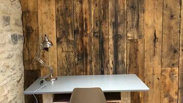 A workspace with a wooden wall, a desk, and a chair.