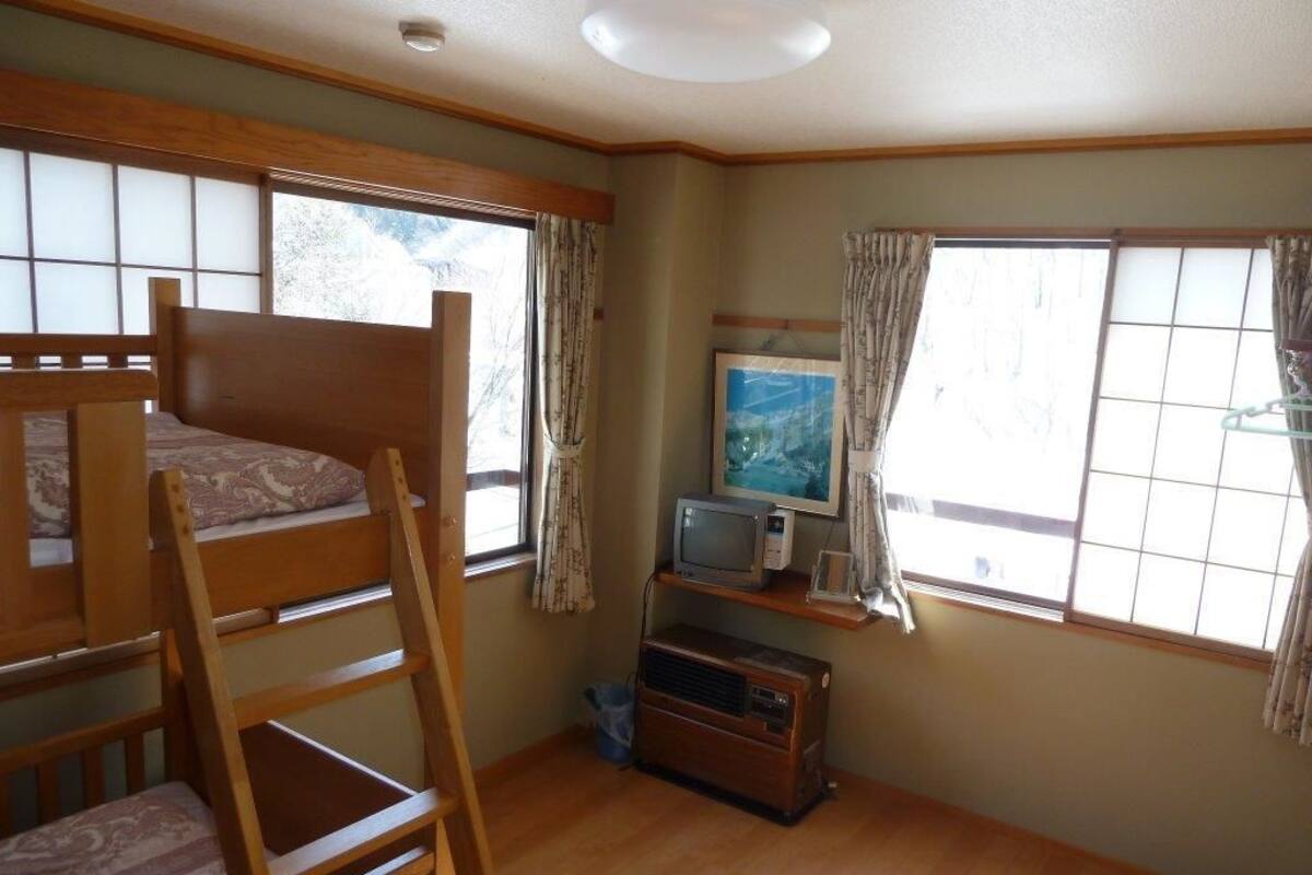 A room with bunk beds, a television, and a small shelf with a picture frame.