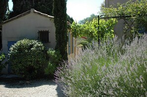 Un bâtiment doté d’un toit en pente, d’une porte avec une fenêtre et d’une allée gravillonnée.