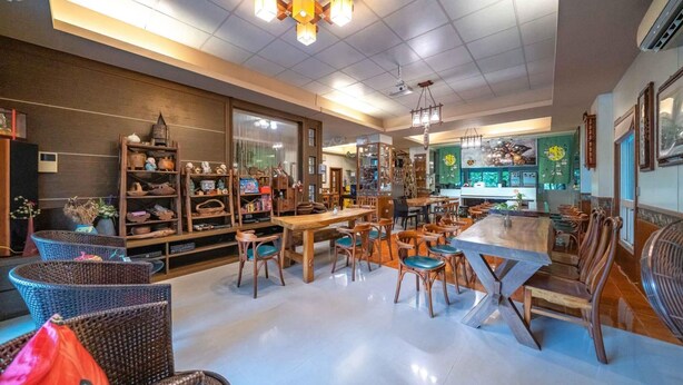 Um restaurante amplo e bem iluminado, com mobiliário de madeira e diversas opções de assentos.