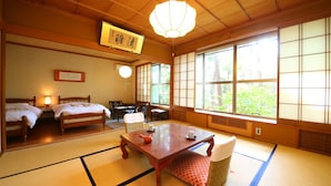 A traditional Japanese room with tatami flooring, a low table with a teapot, two beds, and large windows with shoji screens. - Yudanaka Yumoto (Yamanouchi)