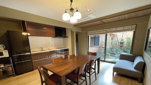 Uma cozinha moderna com armários de madeira, uma mesa de jantar com cadeiras e um forno embutido.