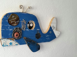 Decoració en forma d'avió blau i blanc amb aspecte antic, amb un petit hèlix i un emblema circular amb text.