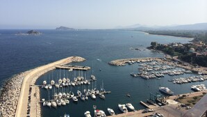 A marina with numerous boats docked, a rocky breakwater, and a view of distant mountains. - Apartment 20 meters from the sea (Tancau sul mare)