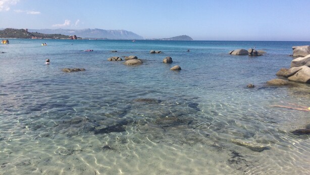 A beach with clear shallow waters, large rocks, and distant mountains. - Apartment 20 meters from the sea (Tancau sul mare)