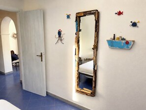 Una habitación con un espejo grande, una cama y una puerta.