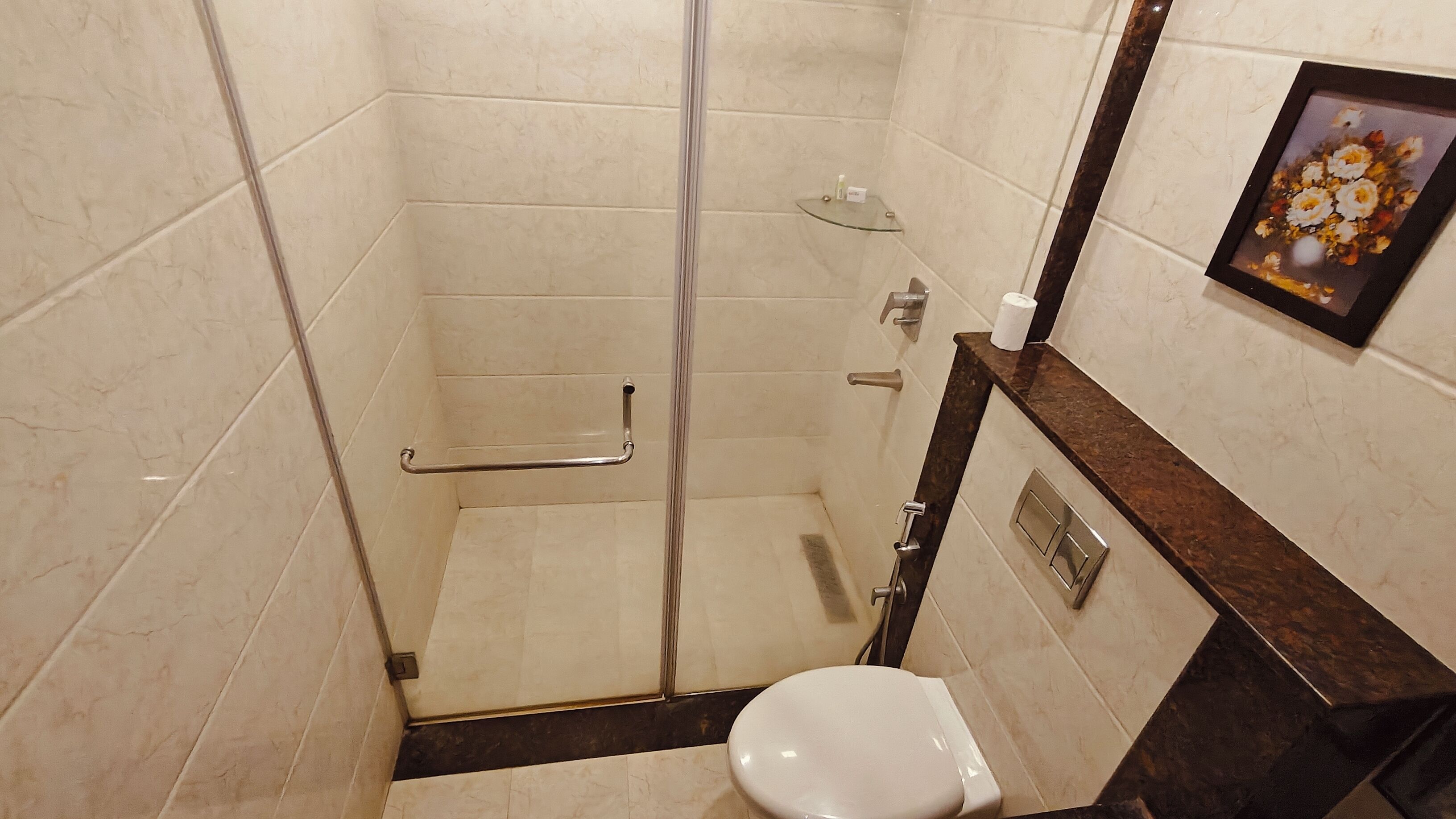 Um banheiro pequeno e moderno, com box de vidro, vaso sanitário e parede revestida em mármore.