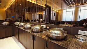A modern kitchen with granite countertops, stainless steel appliances, and a large mirror reflecting the space. - ASR Parklane, A Bergamont Hotel - Hosur (Hosur)