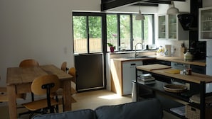 Una cocina moderna con zona de comedor, ventanas amplias y lavavajillas integrado.