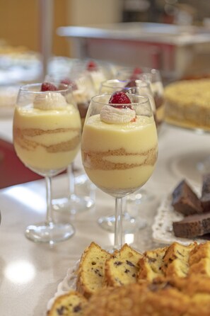 Una mesa de postres con pasteles y repostería.