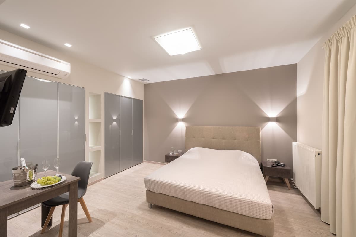 Un dormitorio moderno con cama, mesita de noche y escritorio con silla.