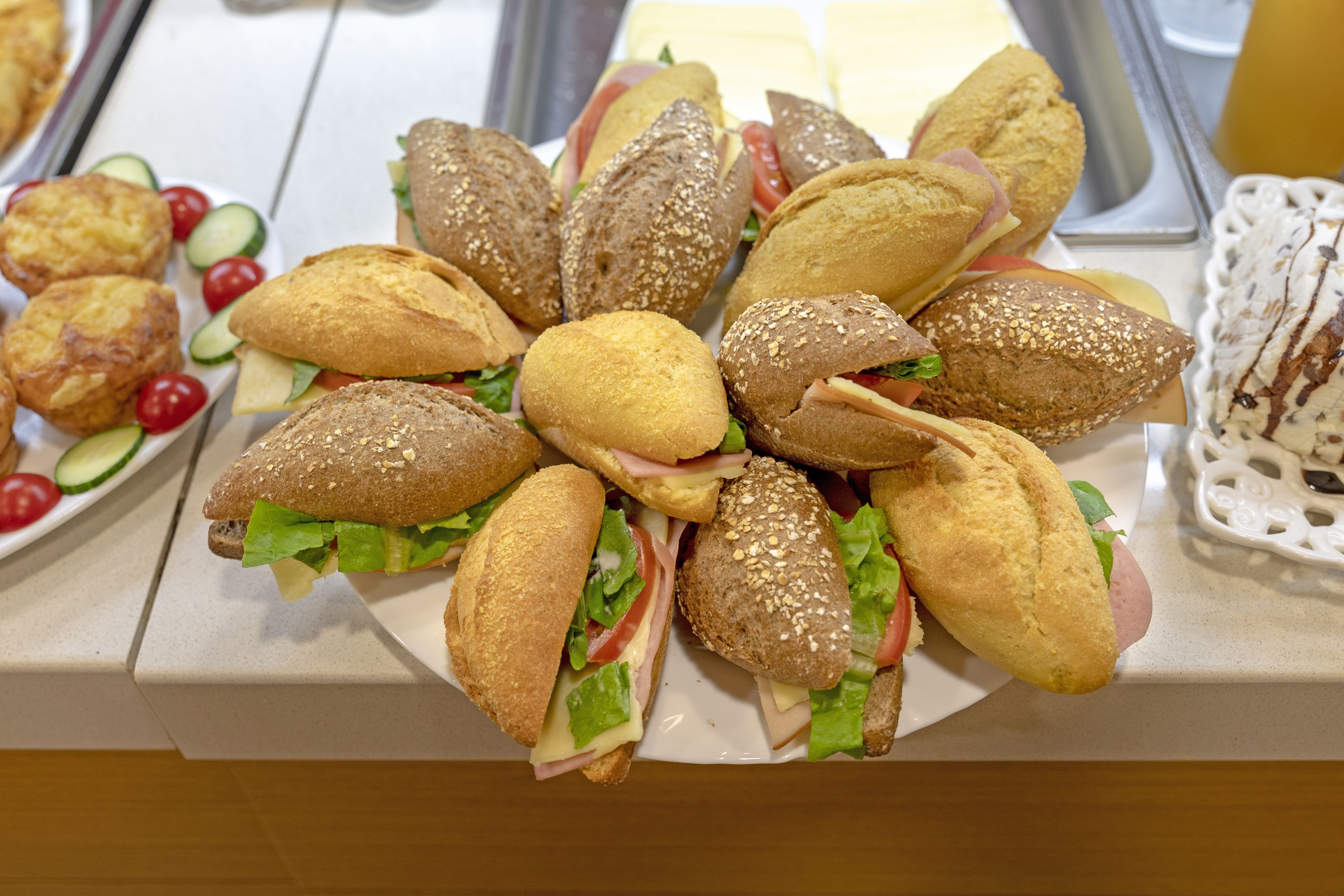 Een buffet met diverse belegde broodjes en gebak.