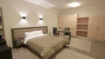 A bedroom with a bed, bedside tables, a desk, and built-in wooden cabinets.