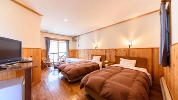 A hotel room with two beds, a TV, a desk, and a chair.